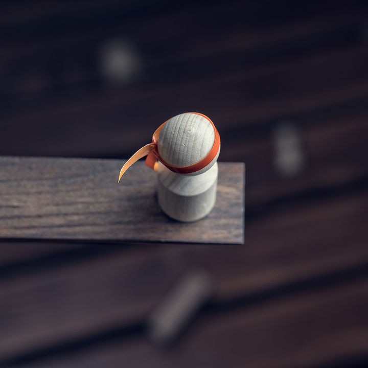 A wooden ball above a plank.