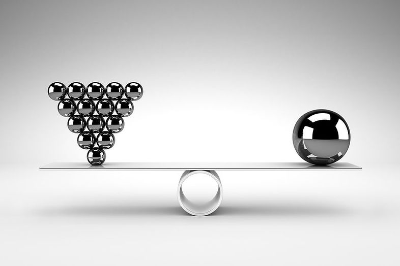 An inverted silver balls placed in a pyramid on the left side and one silver ball balanced on a roll.