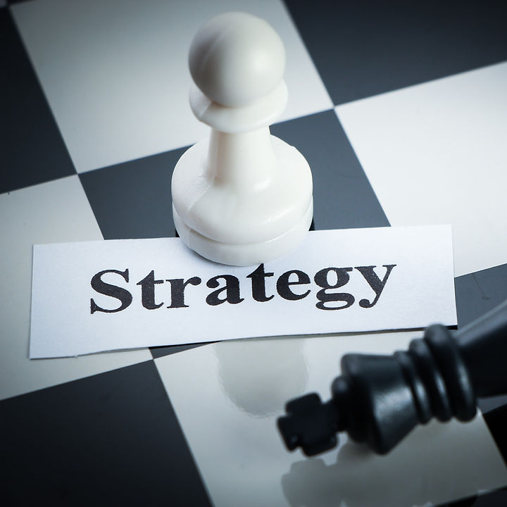 A chess board piece with the word strategy below it.